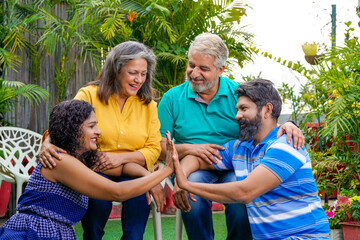 Happy indian family sitting together at outdoor.