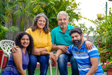 Happy indian family sitting together at outdoor.