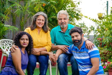 Happy indian family sitting together at outdoor.