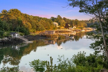 Beautiful scenery of rural houses by the lake and surrounded by greenery in Maine