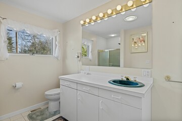 Modern sink with lights above the mirror in the white bathroom