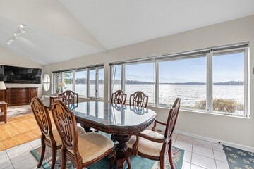 Set of brown table and chairs in the living room with the lake view visible from the window