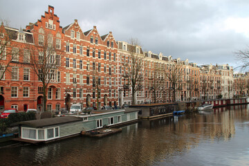 Fototapeta na wymiar canal and old brick houses or flat buildings in amsterdam (the netherlands)
