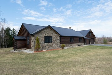 Beautiful contemporary rustic log cabin on a rural field in the mountains