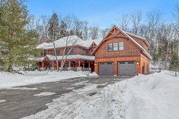 Closeup of a contemporary rustic home covered in snow in the mountains