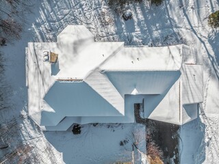Top view of a contemporary rustic home covered in snow in the mountains