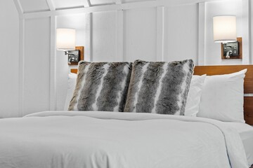 a white bed with a brown headboard sitting in a room