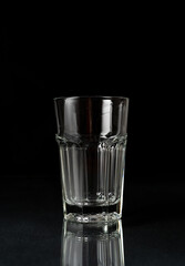 Empty glass on black background. Empty thick glass tumbler on dark background

