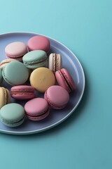 Fototapeta premium Cake macaron or macaroon on plate close-up from above, blue background, colorful almond cookies, pastel colors, greeting card, top view, flat style. French delicious dessert. Image is AI generated.