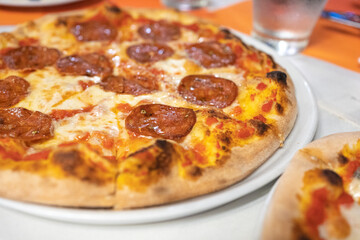 Pepperoni pizza. Close up of homemade fresh Italian Pepperoni pizza with cheese on white table background. Pizza is traditional food by Italian at Italy