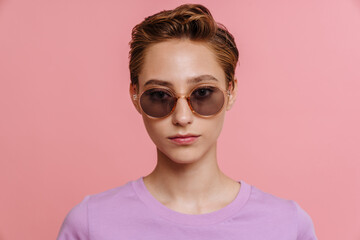 Young beautiful serious woman in sun glasses looking at camera