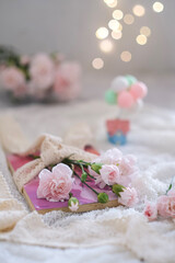 still life pink carnation flowers on a book
