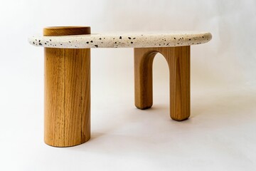 Modern oval designed table with oak wood legs and terrazzo top isolated on a white background