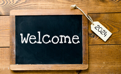 WELCOME 2024 words on chalk board and tag. Concept for business.