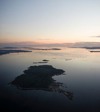 Aerial view of Cortegada island and bateas, mussels farms during sunset in Ria de Arousa, Pontevedra, Galicia, Spain.