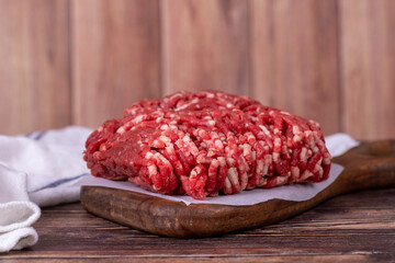 Minced meat on wood background. Raw minced cow meat or ground meat