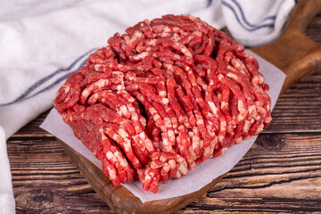 Minced meat on wood background. Raw minced cow meat or ground meat. Close up