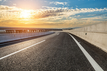 Asphalt road and sky clouds at sunset. Road and sky background.