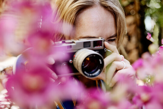 Woman taking photo through camera in garden