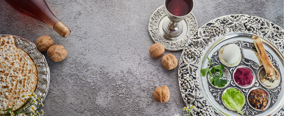 Passover Seder plate with traditional food, walnuts, matza and wine on grunge background