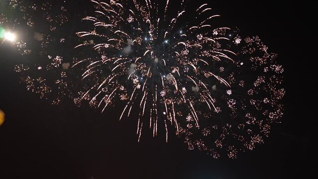 Fireworks sparkling on dark night sky outdoors. Bottom view spectacular light show on festival