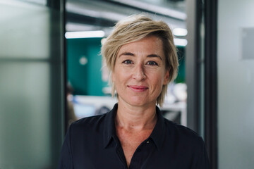 Smiling businesswoman with blond hair in office