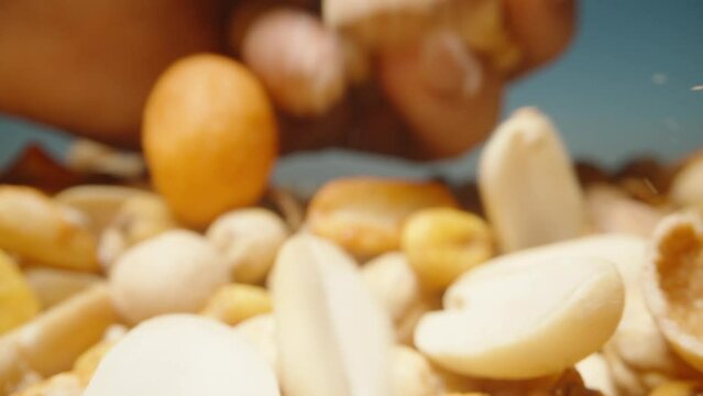 I pour the mixture of nuts and corn grains from my hand onto the table. Macro zoom.