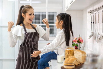 Portrait of enjoy happy love asian family father and mother with little asian girl smiling and having protein breakfast drinking and hold glasses of milk, ,strong and growth at table in kitchen