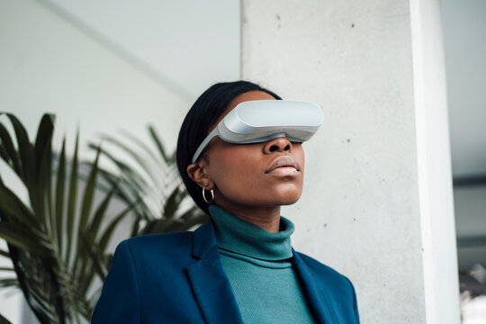 Businesswoman wearing virtual reality headset at office