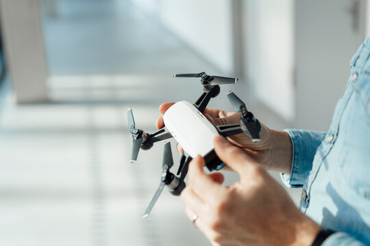 Businessman analyzing drone in corridor