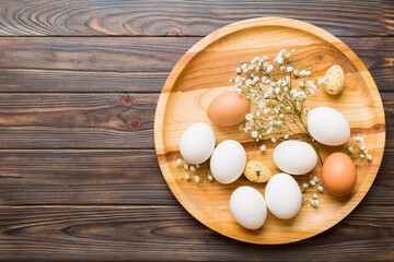 Happy Easter composition. Easter eggs in basket on colored table with gypsophila. Natural dyed colorful eggs background top view with copy space