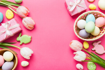 Easter frame with eggs, gift box and tulip on a colored background. The minimal concept. Top view Happy Easter composition. Card with a copy space of the place for the text