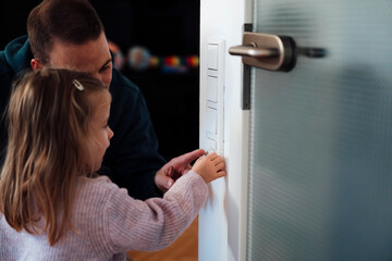 Daughter with father adjusting temperature at home