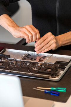 Hands of man repairing laptop