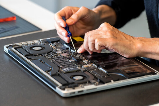 Man repairing laptop with screwdriver