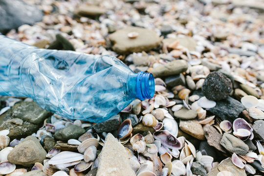 Plastic bottle with seashells at beach