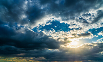 Fototapeta na wymiar Sunbeams breaking through dramatic cumulus clouds. Change of weather. Hope or religion concept.