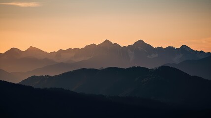 Fototapeta premium A serene sunset over a mountain range with warm, golden tones illuminating the peaks