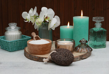 Spa Komposition mit Massageöl, Kerzen und Orchideenblüte.	