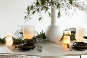 Complete Christmas dinner table decoration with candle lights and wine glasses 