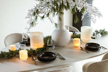 Complete Christmas dinner table decoration with candle lights and wine glasses 