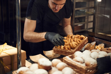 Taking the bakery made meal. Man is taking food in the workspace. Conception of sweet desserts