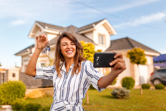 Woman taking a selfie with her new house keys