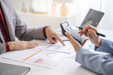 Close up hand man and woman planning budget, using calculator and laptop, reading documents, young female checking finances, counting bills or taxes, online banking services, sitting at desk