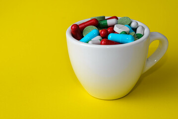 Colourful different pills or medicine capsules in a cup