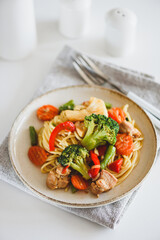 Whole wheat organic pasta with vegetables on white wooden table