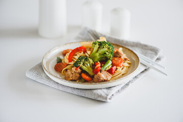 Whole wheat organic pasta with vegetables on white wooden table