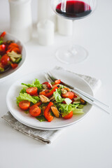 Fresh salad with mussels and tomatoes on white wooden table
