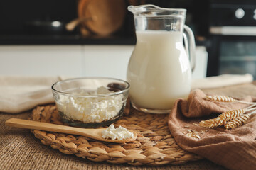milk jug and bowl of cottage cheese on wooden kitchen table
