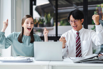 Business people celebrate with laptop success happy pose. E-commerce, internet technology, or startup small business concept. Modern office